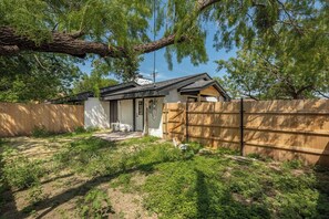 Un immobile residenziale con cortile recintato, garage separato e una casa dal tetto scuro.