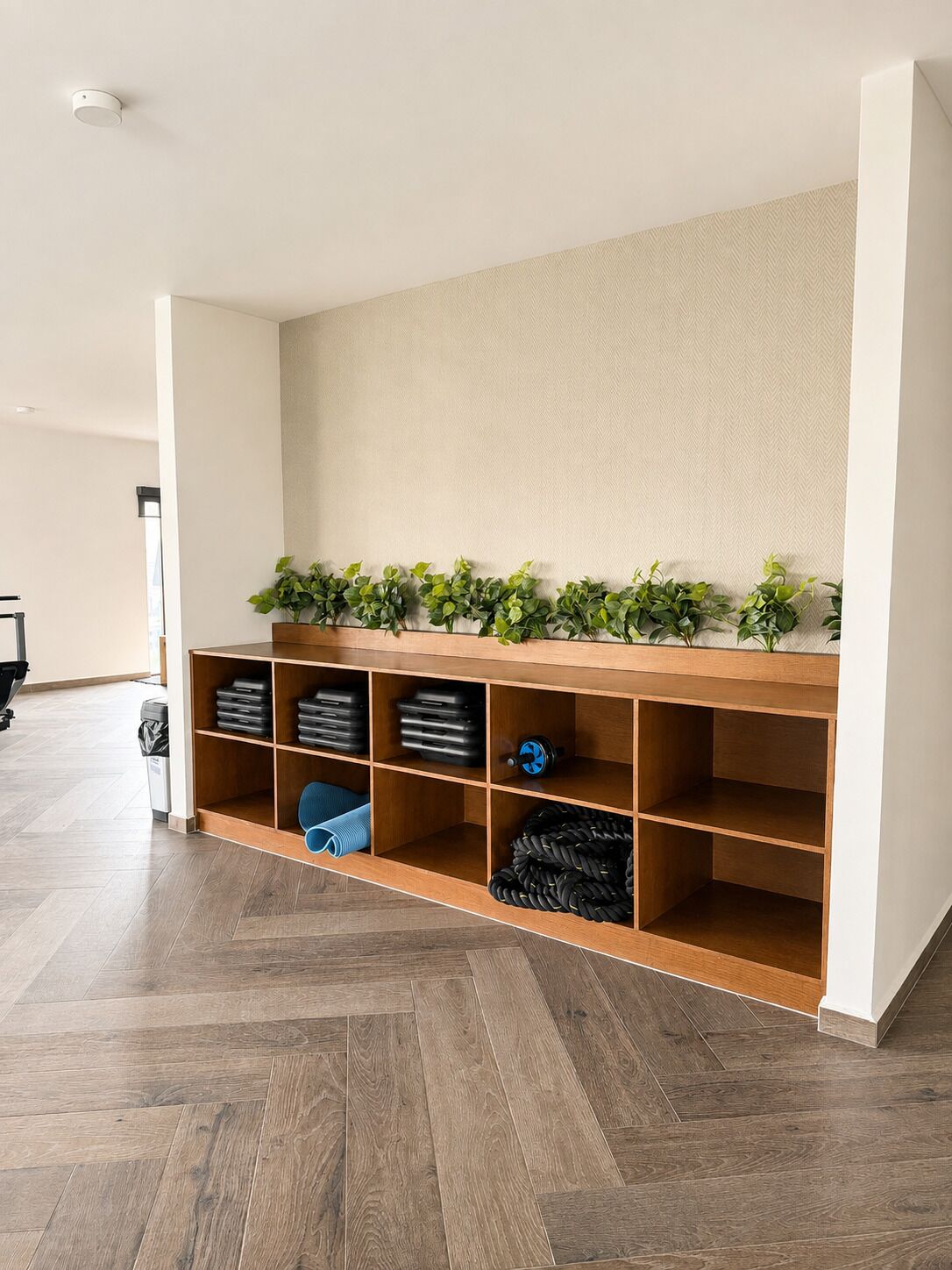 A storage area with shelves containing various items, a wooden bench, and a wall-mounted plant.