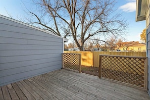 A wooden deck with a lattice fence, a shed, and a tree in the background. - NEW RENO! 4BR-2bath Modern Home | Central Location (Abilene)