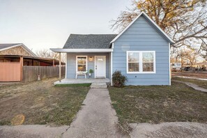 Una casa a un piano con portico anteriore, un piccolo giardino e una cassetta postale.