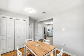 A modern kitchen with white cabinets, a wooden dining table, and a chandelier. - Bright & Stylish 3bed 2bath Abilene Home (Abilene)