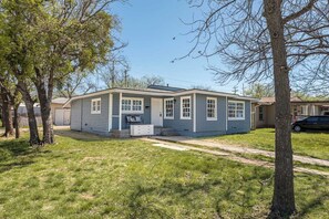 A single-story house with a front porch, a small attached garage, and a lawn. - Bright & Stylish 3bed 2bath Abilene Home (Abilene)