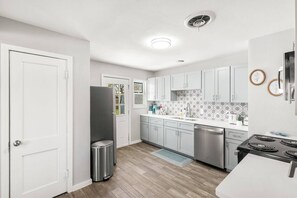 A modern kitchen with white cabinets, stainless steel appliances, and a tiled backsplash. - Bright & Stylish 3bed 2bath Abilene Home (Abilene)