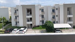 Ein mehrstöckiges Wohngebäude mit Balkonen, einem Parkplatz und blauem Himmel.