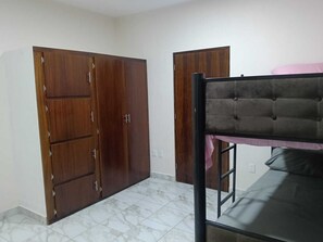 A room with a bunk bed, two wardrobes, and a tiled floor. - Garden View | Trampoline | Free Parking (Mezcales)