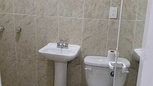 Ein Badezimmer mit einem Standwaschbecken, einer Toilette und einem Bidet.