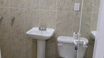 A bathroom with a pedestal sink, a toilet, and a bidet.