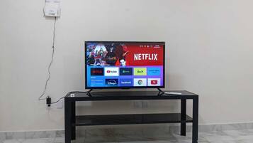 A television on a black stand with a visible power cord.
