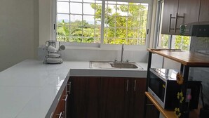 Eine Küche mit Fenster, Spüle und Schränken.