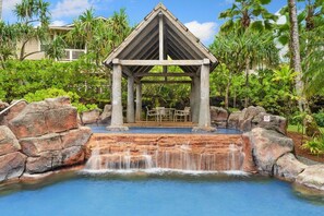 A gazebo with a waterfall, surrounded by rocks and greenery. - Modern Island Retreat | Pool & A/C | Mins to Beach (Princeville)