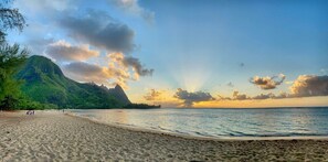 Ein Strand mit einem Berg im Hintergrund und klarem Himmel.