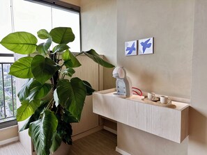 A modern bathroom with a large potted plant, a coffee machine, and two wall-mounted artworks. - Panoramic Skyline Studio in São Paulo (São Paulo)