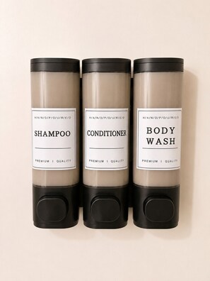 Three cylindrical containers labeled 'SHAMPOO,' 'CONDITIONER,' and 'BODY WASH' with a black base. - Cozy 1-bedroom apartment in peaceful Dallas with AC (Dallas)