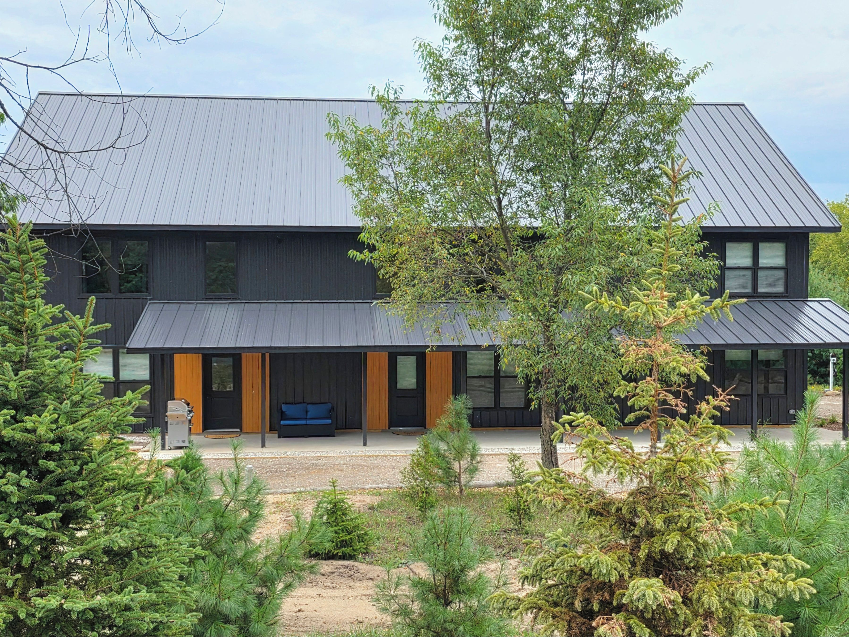 Een modern gebouw met twee verdiepingen, een plat dak, grote ramen en een overdekt terras.