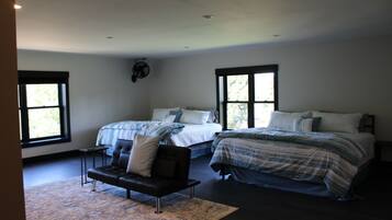 A bedroom with two beds, a sofa, and a fan.