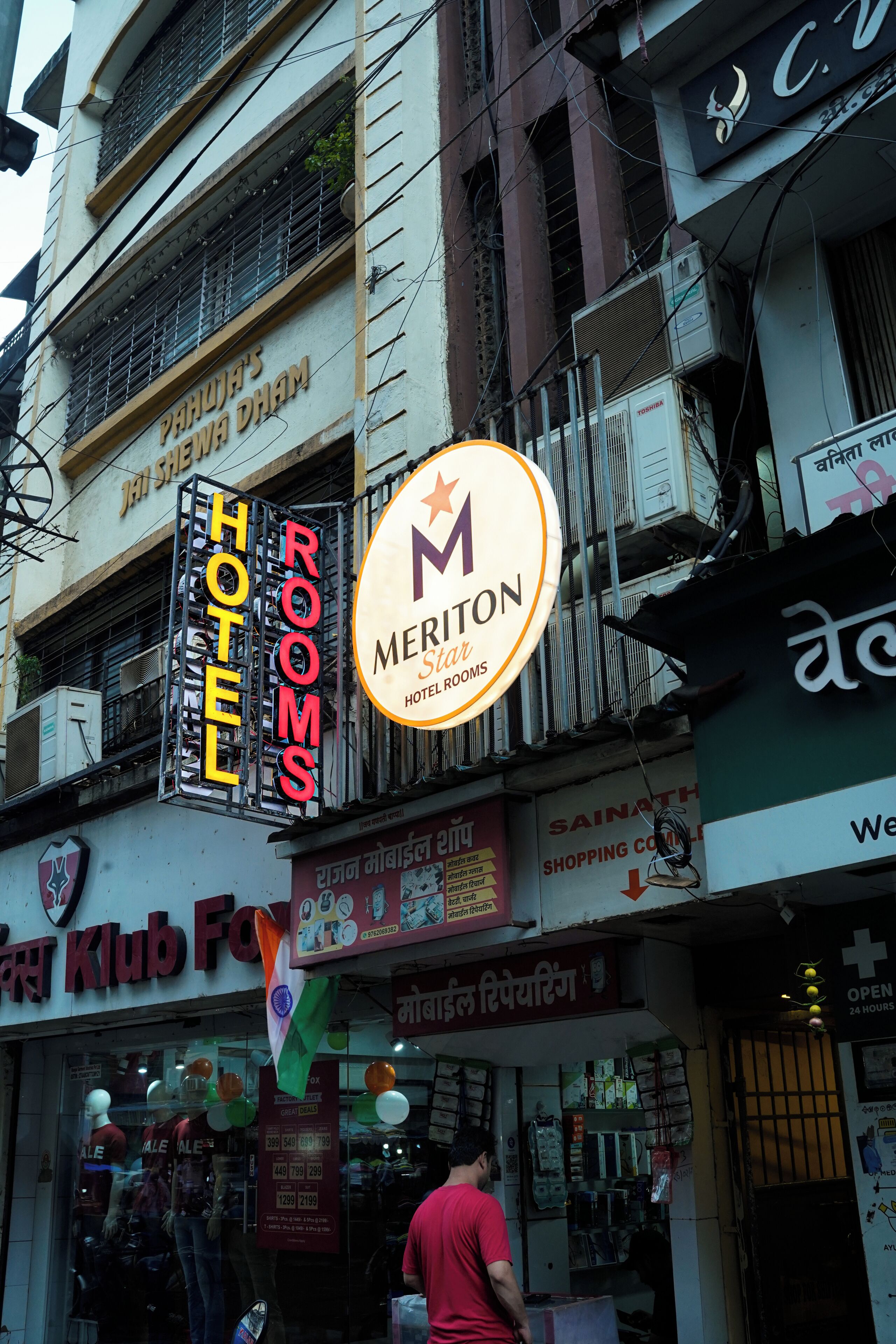 A hotel sign with 'HOTEL ROOMS' and a 'MERITON HOTEL ROOMS' sign.
