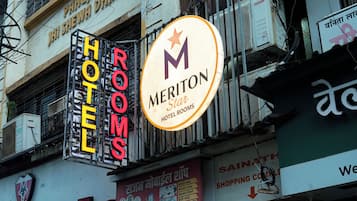 A hotel sign with 'HOTEL ROOMS' and a 'MERITON HOTEL ROOMS' sign.
