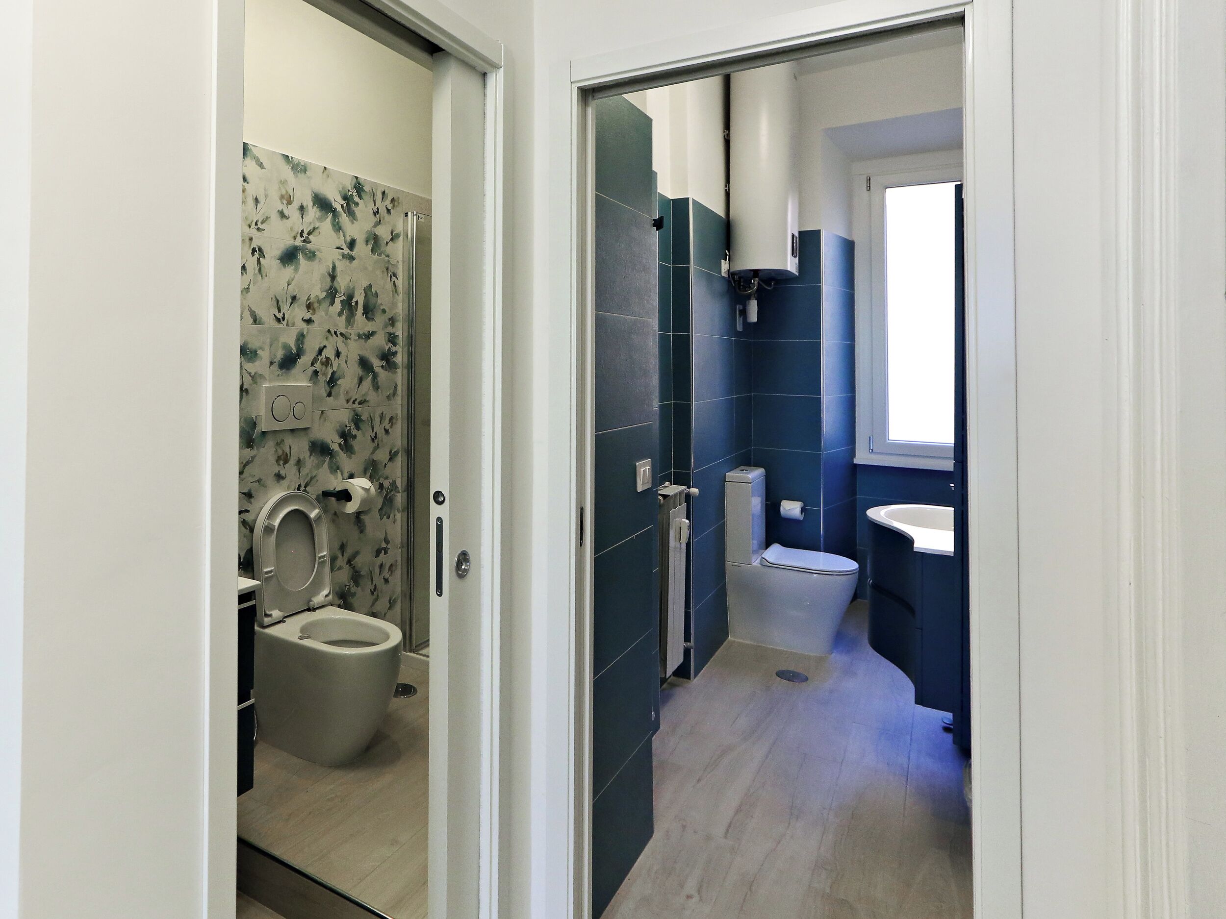 Et badeværelse med toilet, håndvask og bruseområde.