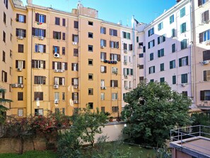 A multi-story building with balconies, air conditioning units, and a small courtyard with plants. - Vanella Luxury Apartment Rome (Roma)