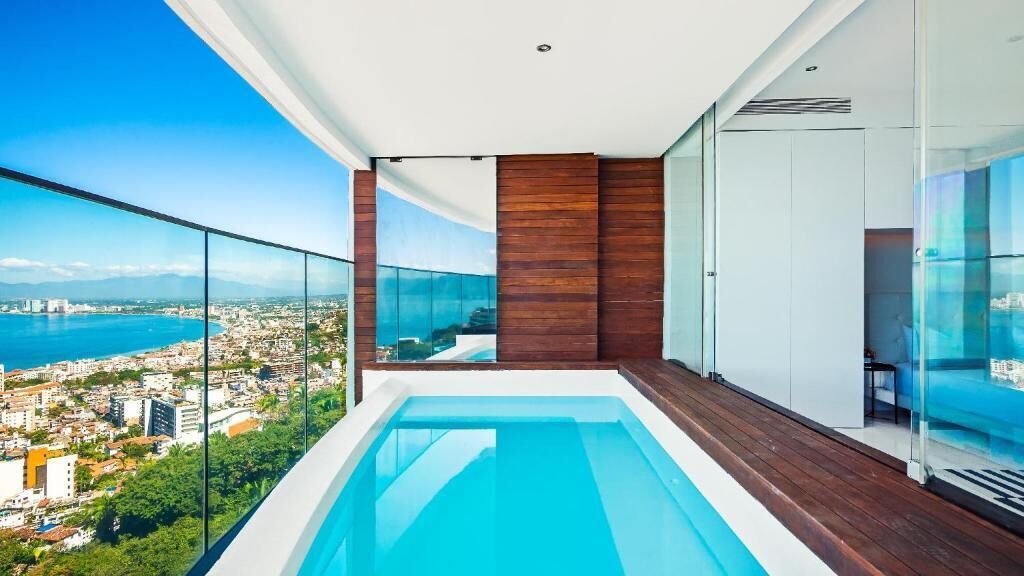 Ein moderner Balkon mit Pool, der Blick auf eine Stadt und das Meer gewährt.