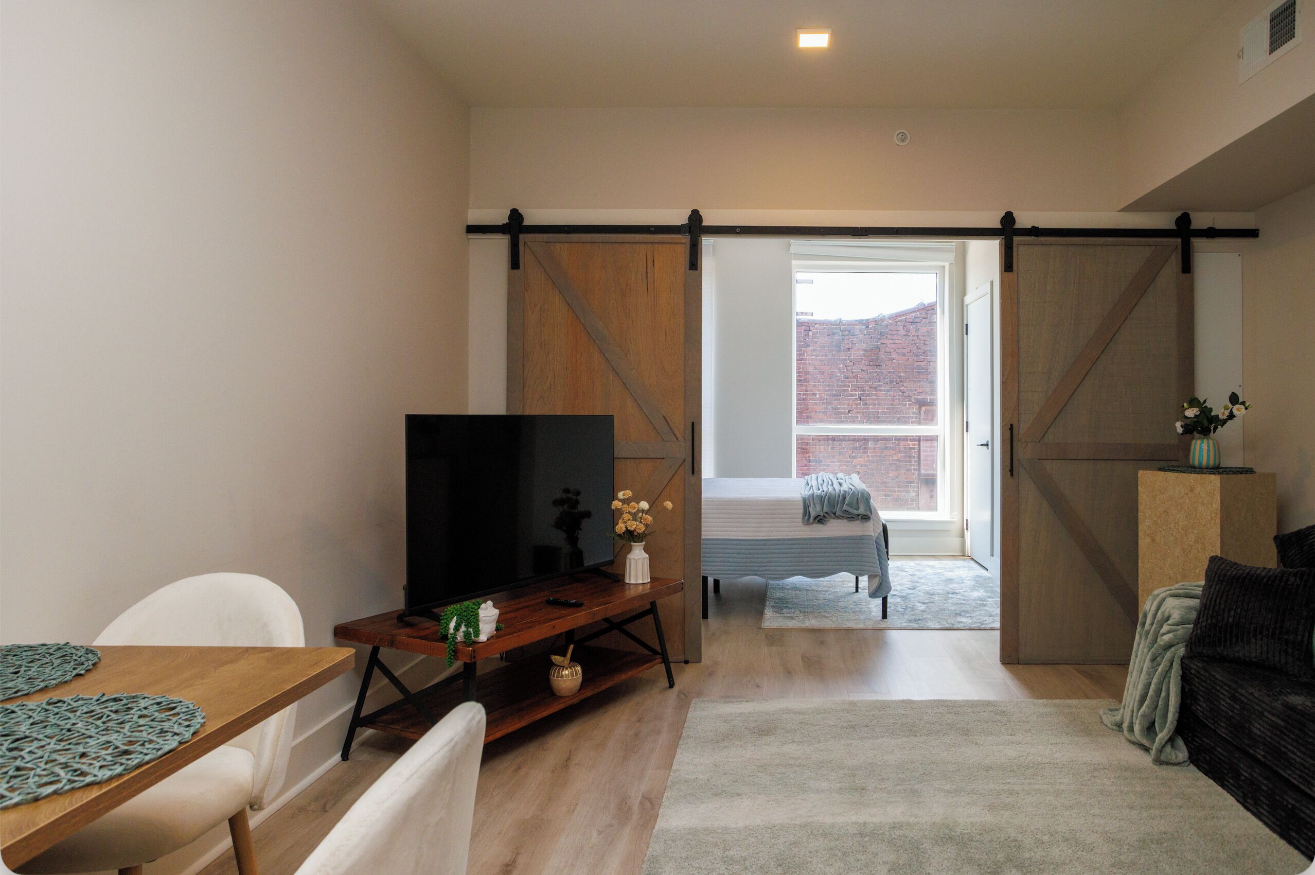 Una sala moderna con una televisión, un sofá y un comedor.