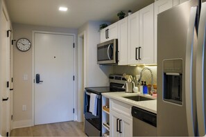 Una cocina funcional con microondas, horno, lavavajillas y refrigerador.