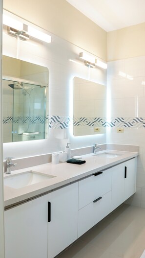 A modern bathroom with two sinks, a large mirror, and patterned tiles. - Beautiful 3-bedroom house with AC in charming Ocho Rios (Ocho Rios)