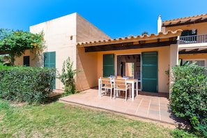 A residential property with a patio, a dining table with chairs, and a small garden area. - Casa Massieu - Relax steps from the beach (Ciutadella de Menorca)
