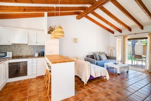 A compact kitchen with white cabinets, a built-in oven, and a tiled backsplash. - Casa Massieu - Relax steps from the beach (Ciutadella de Menorca)