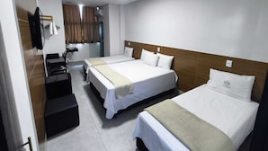 Habitación de hotel con dos camas, un escritorio y un espejo.