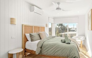 A bedroom with a bed, a ceiling fan, and a view of the outdoors. - Casa En Norah | Coastal Escape (Norah Head)