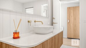 A modern bathroom with a white vanity, a vessel sink, and a mirror. - Casa En Norah | Coastal Escape (Norah Head)
