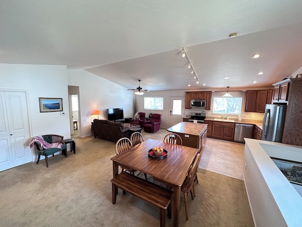 A spacious living area with a dining table, a sofa, and a television. - Black Dog Inn - Minutes from The Gorge (Quincy)