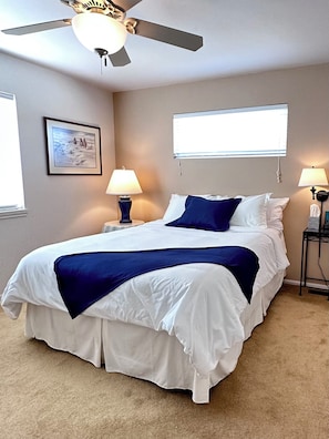A bedroom with a bed, two bedside lamps, a ceiling fan, a window, and a framed picture on the wall. - Black Dog Inn - Minutes from The Gorge (Quincy)