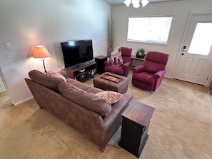A living room with a brown sofa, a television, a lamp, and a red armchair. - Black Dog Inn - Minutes from The Gorge (Quincy)