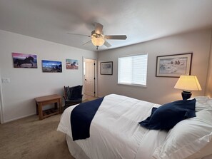 A bedroom with a bed, a chair, a desk, and a ceiling fan. - Black Dog Inn - Minutes from The Gorge (Quincy)