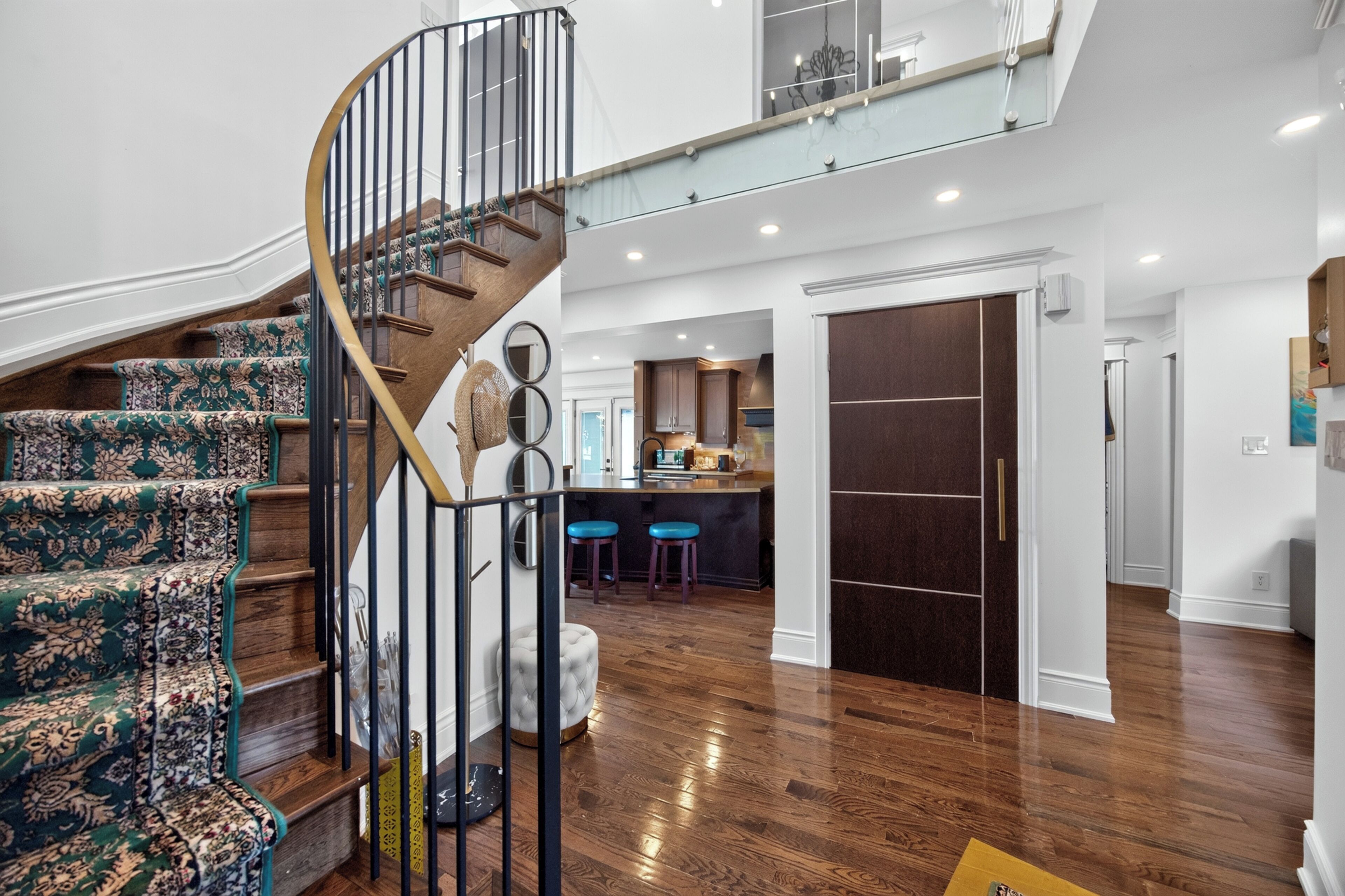 Un interior moderno con una escalera en espiral, una zona de cocina y un espacio para comer.