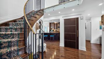Un interior moderno con una escalera en espiral, una zona de cocina y un espacio para comer.