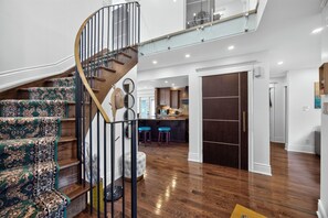 Un interior moderno con una escalera en espiral, una zona de cocina y un espacio para comer.