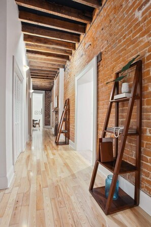 Hall | Interior Hallway Connecting Bedrooms with Exposed Beam Ceiling and Brick Wall | Third Floor of Building — Unit on One Level - Stylish CBD Loft , 5 min to French Quarter (New Orleans)