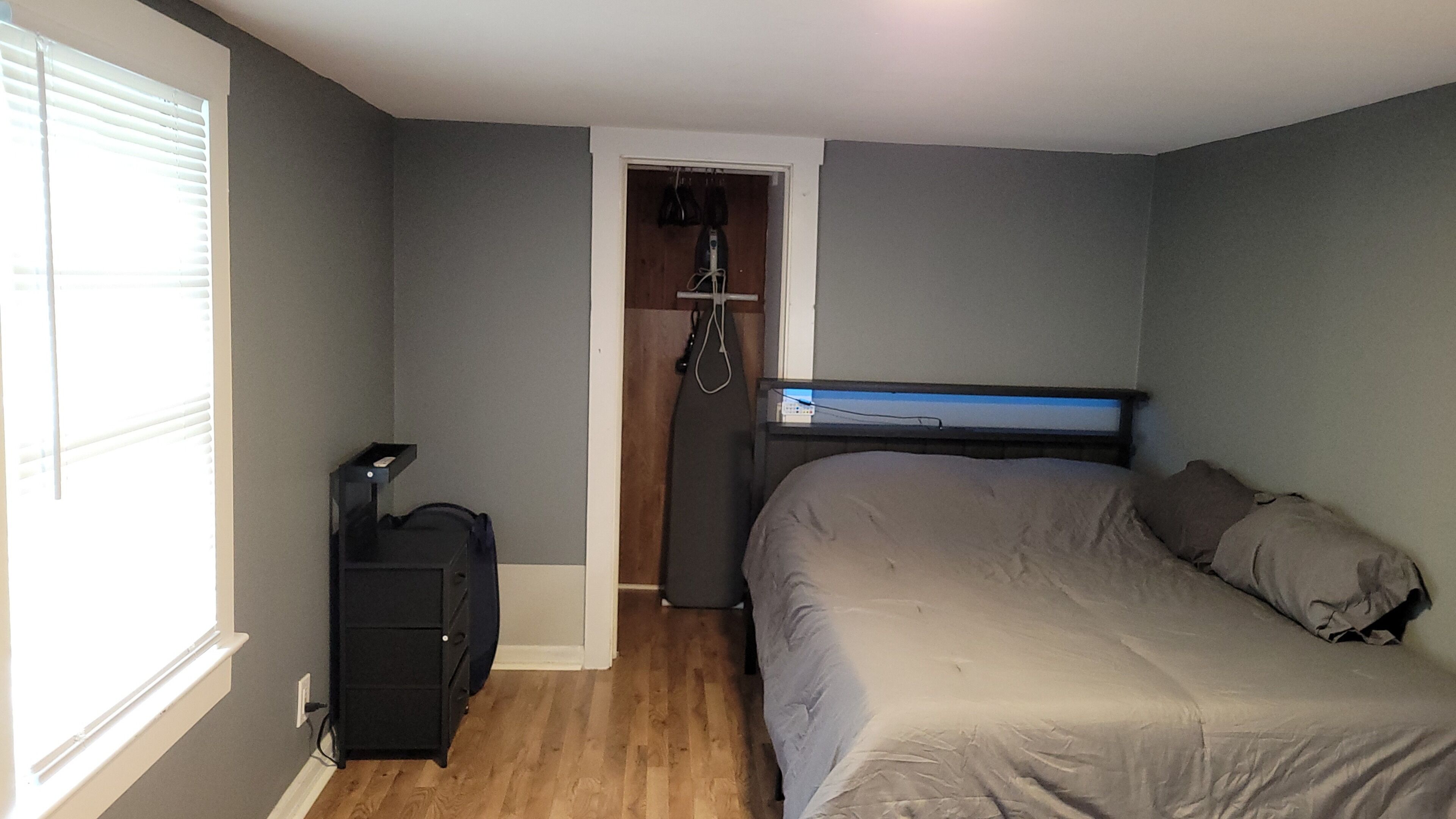 Une chambre à coucher avec un lit, une armoire, un bureau et une fenêtre.