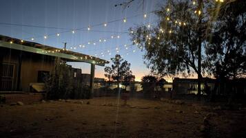 A fenced outdoor area with string lights, a building with a flat roof, and a sign that reads 'CASA'.