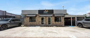 Een gebouw met een bord waarop 'Punto Ceviche' staat en een auto die ervoor geparkeerd staat.