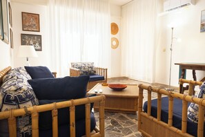 A living room with a sofa, armchair, and a small table with a bowl. - Marina: 90 m² with a terrace, 200 m from the sea – up to 6 guests (Marina di Grosseto)