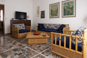 A living room with a television, two sofas, a coffee table, and a patterned rug. - Marina: 90 m² with a terrace, 200 m from the sea – up to 6 guests (Marina di Grosseto)