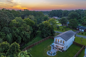 A two-story house with a fenced backyard, a patio with outdoor furniture, and a swimming pool. - The Palmetto Haven House (North Charleston)