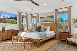 Un dormitorio moderno con una cama grande, un banco, una mesita de noche y vistas al exterior.
