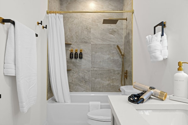 Et moderne badeværelse med bruser, toilet og håndvask.