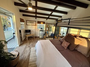 Een slaapkamer met een stapelbed, een bureau met een computer en een zithoekje.
