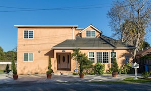 A two-story residential house with a front porch, a garage, and a driveway.
